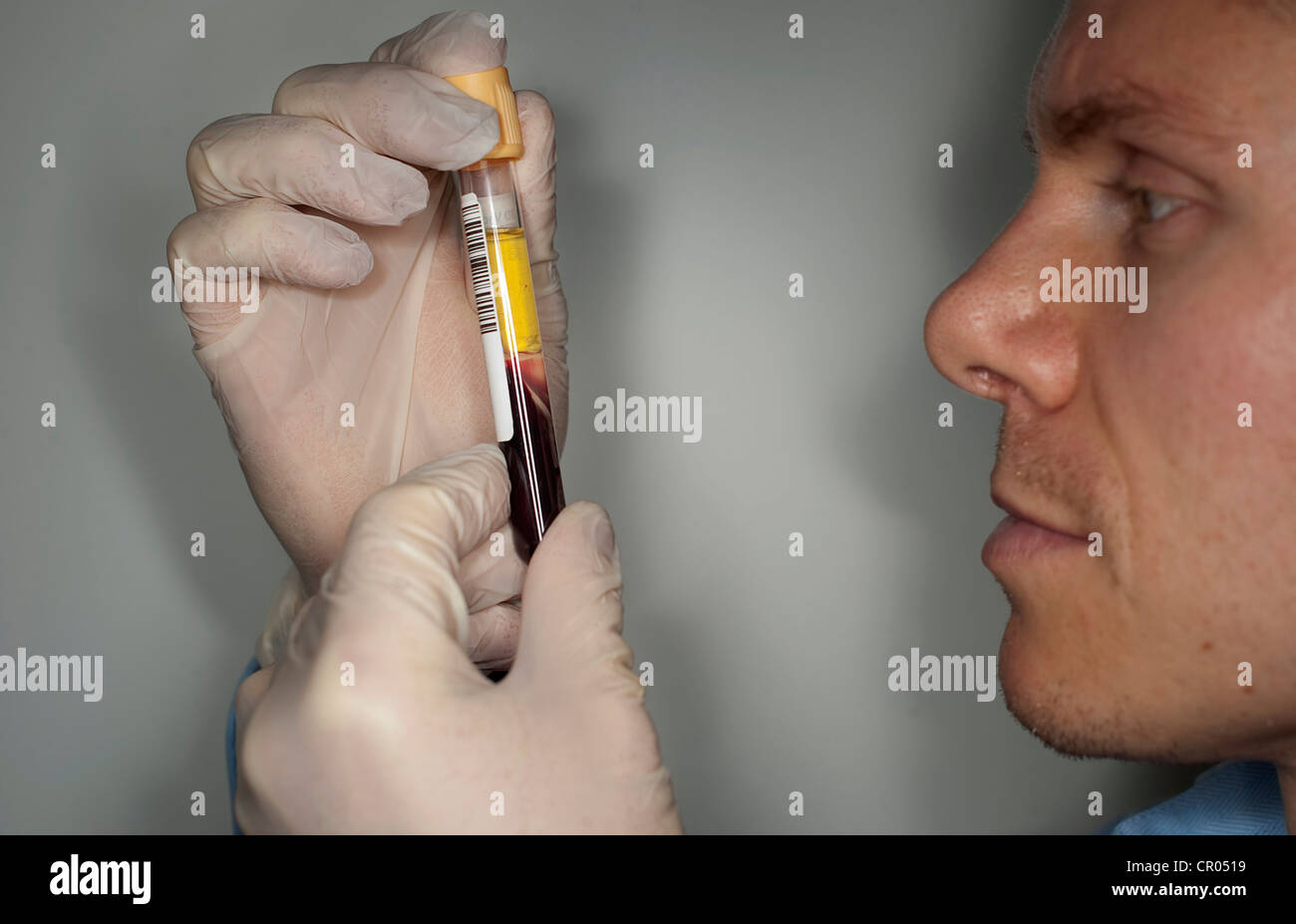 A doctor looks at a blood sample during a health check at a Nuffield