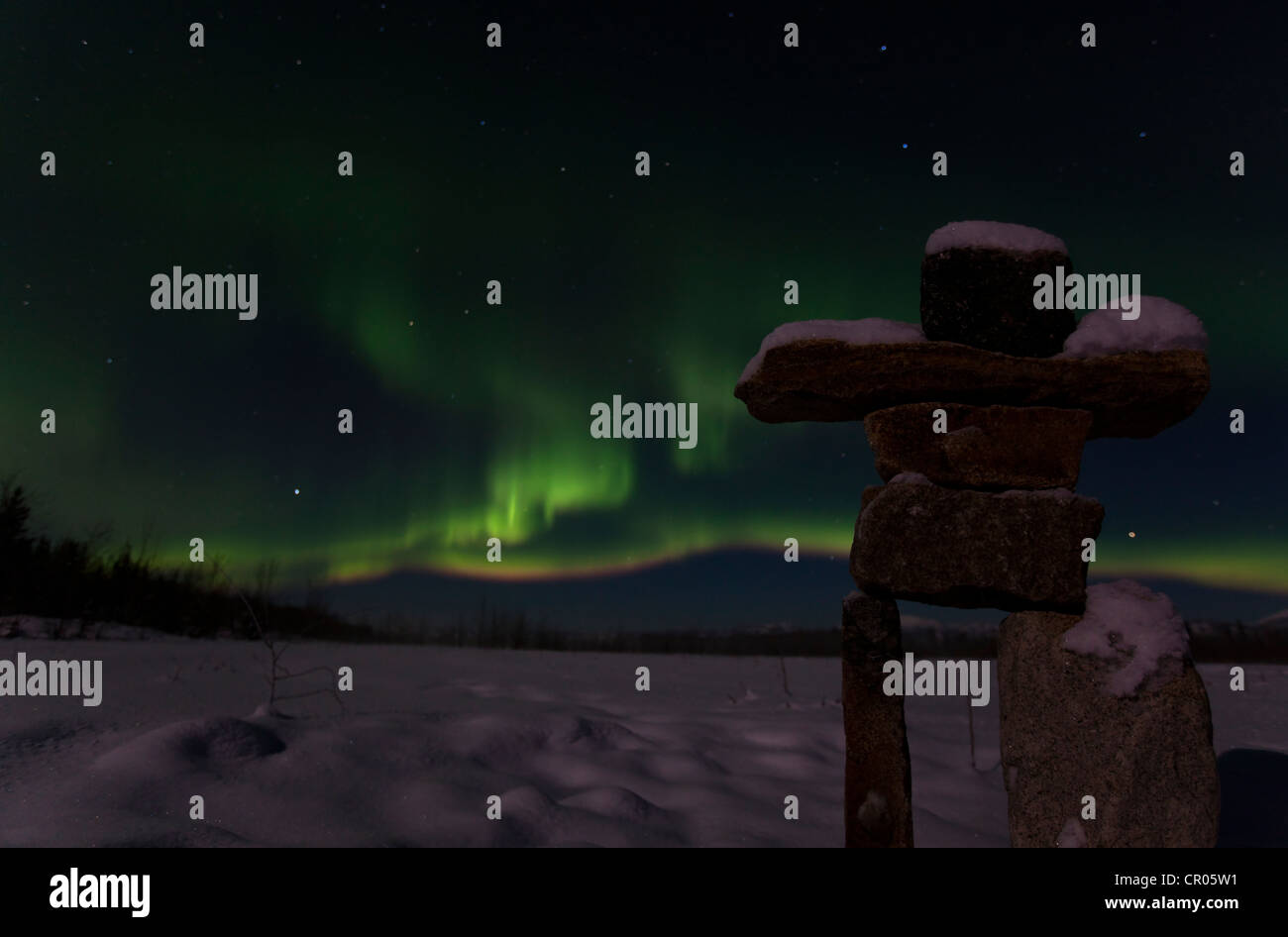 Silhouette of Inuit stone man, inukshuk, inuksuk, stone landmark or cairn, Northern lights, Polar aurora or Aurora Borealis Stock Photo