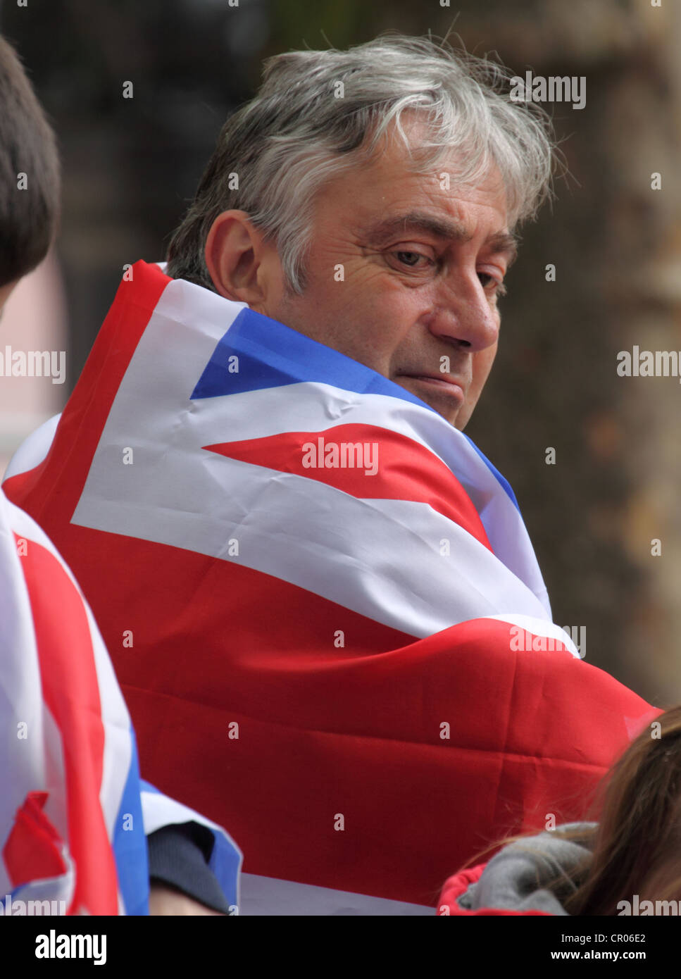 Man wearing a Union flag on the Mall at Buckingham Palace awaiting the arrival of the Queen. Stock Photo
