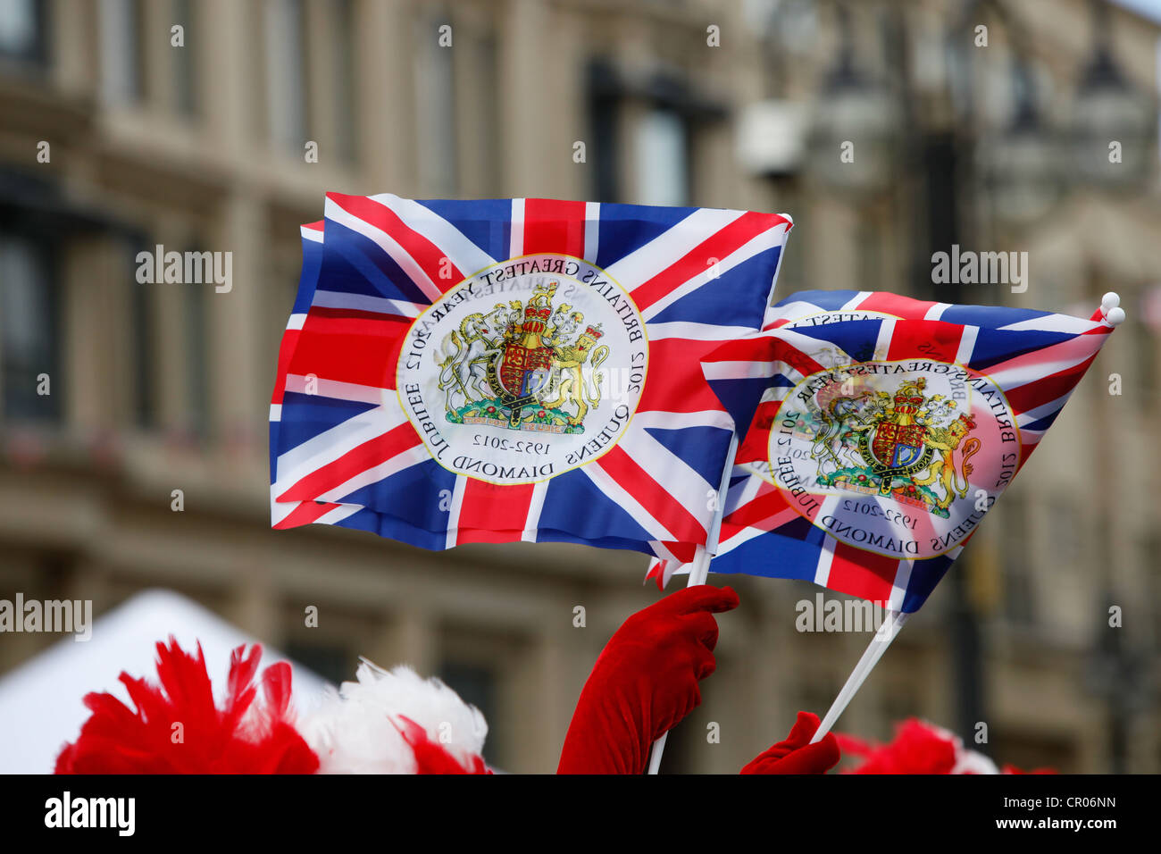Red gloved hands waving Union Jack flags during Queens Diamond Jubilee