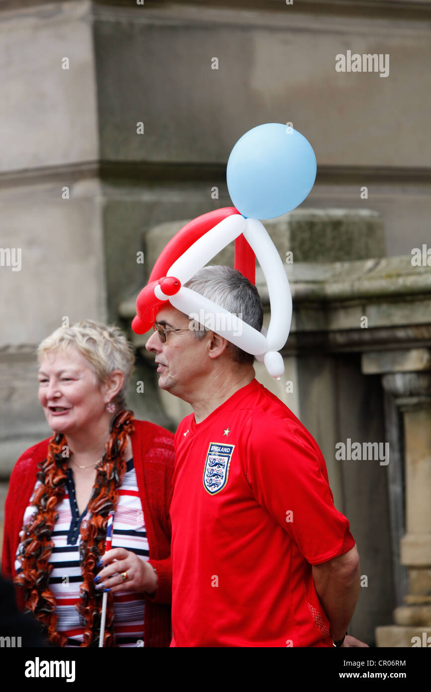 Man wearing a "hat" made from balloons coloured red white and blue