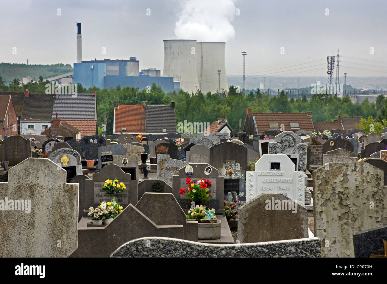 Cemetery and view over cooling towers of the Amercoeur power plant in Roux, Charleroi, Belgium Stock Photo