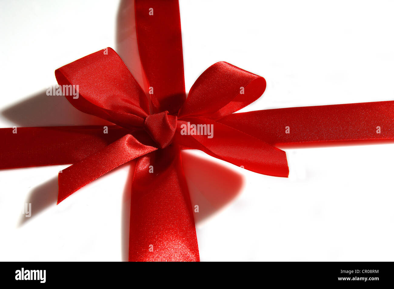 Black gift box wrapped with a red and tan natural raffia bow on a white  background. Horizontal shot. Isolated on white Stock Photo - Alamy