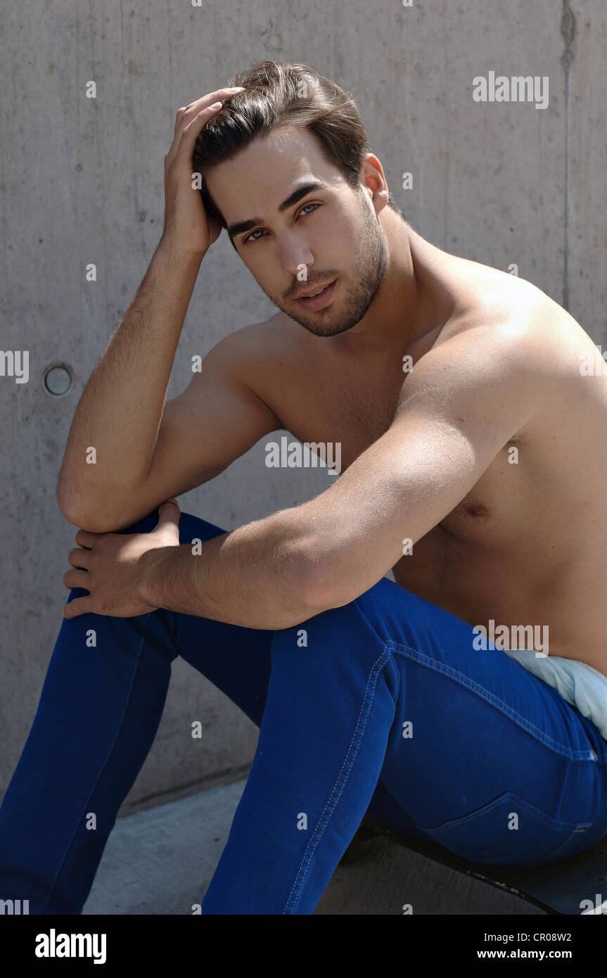 Young shirtless skater in front of