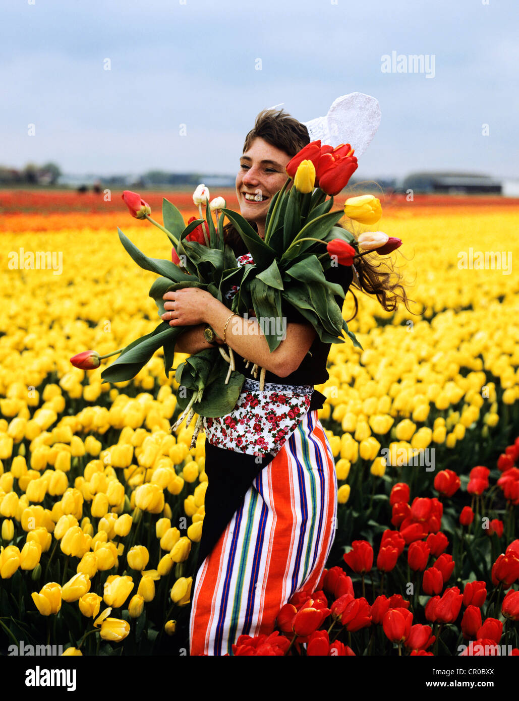 Netherlands. Keukenhof. Young woman in traditional costume in Tulips