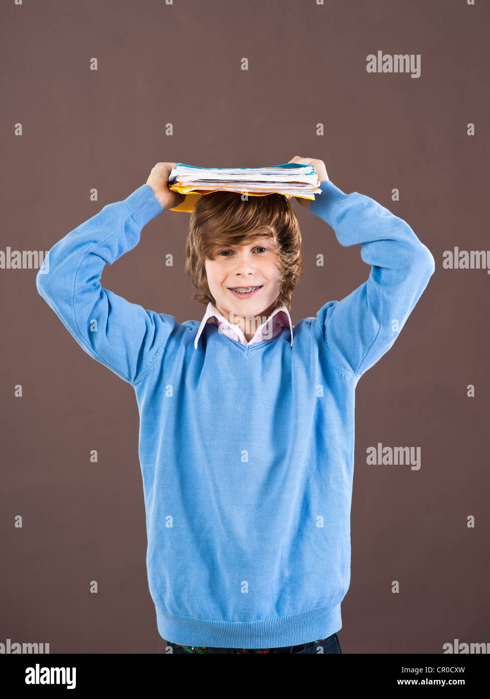 Boy holding school books on his head Stock Photo