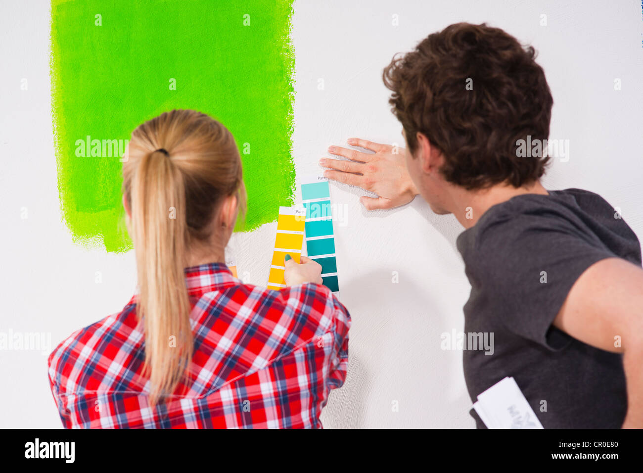 Young couple using colour cards to select a wall paint colour Stock Photo