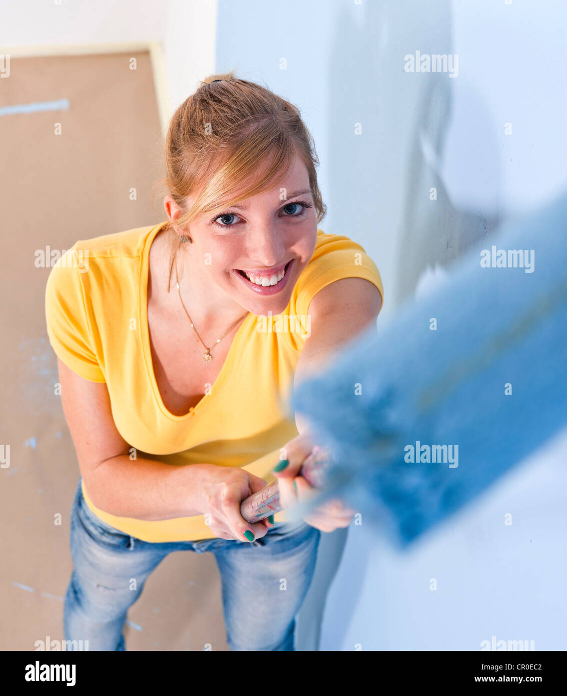 Young woman painting a wall Stock Photo - Alamy
