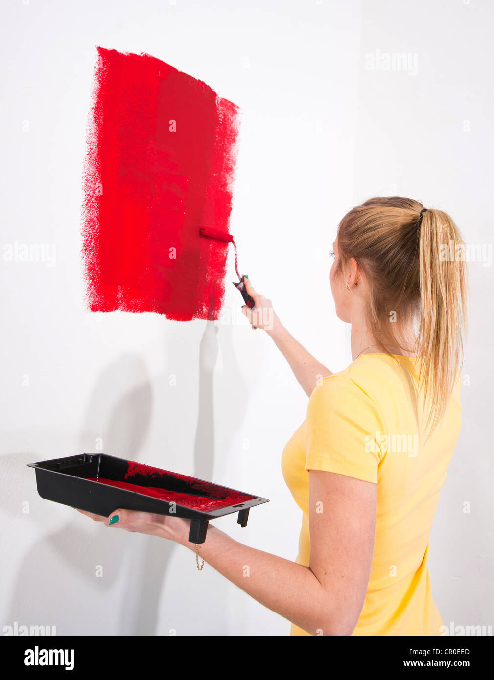 Young woman painting a wall Stock Photo - Alamy