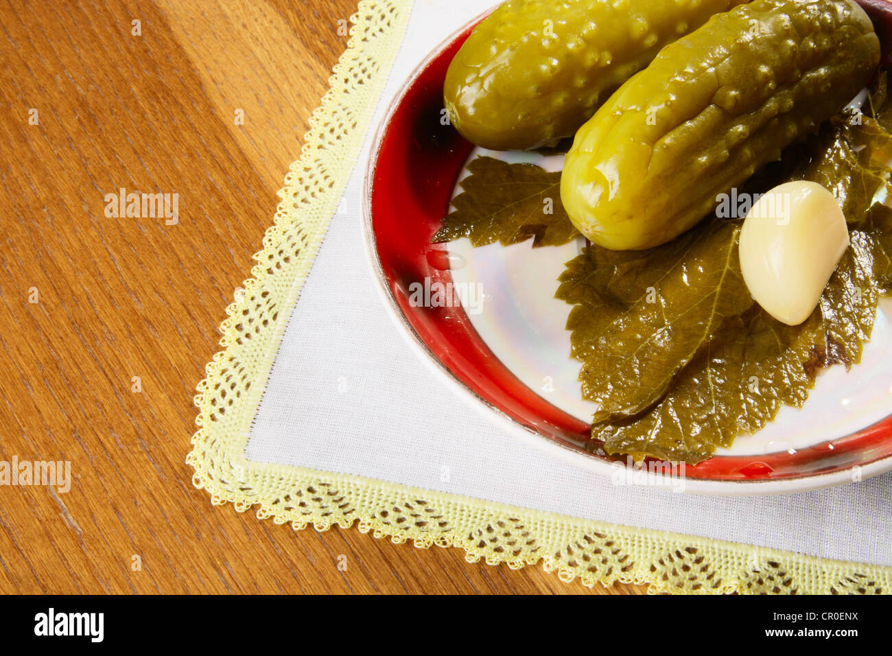 Plate with marinated cucumbers, garlic and leaf of currant Stock Photo