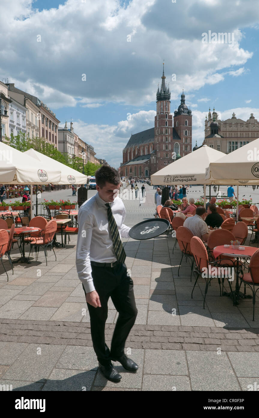 Waiter with serving tray at pavement cafe in Main Market Square, Krakow, Poland. Stock Photo