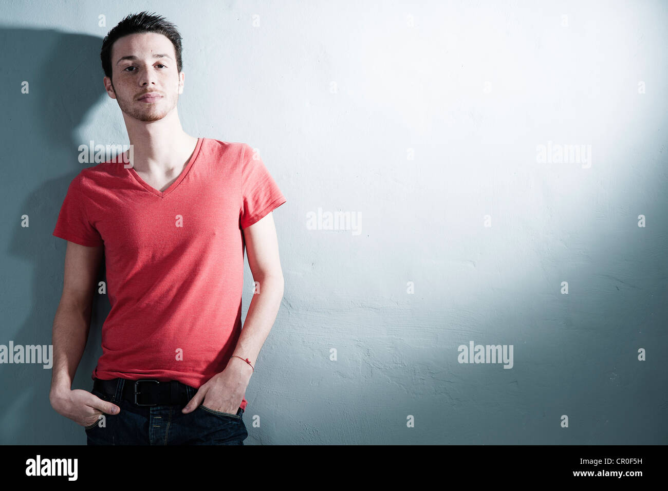 Cool young man leaning against a wall Stock Photo - Alamy
