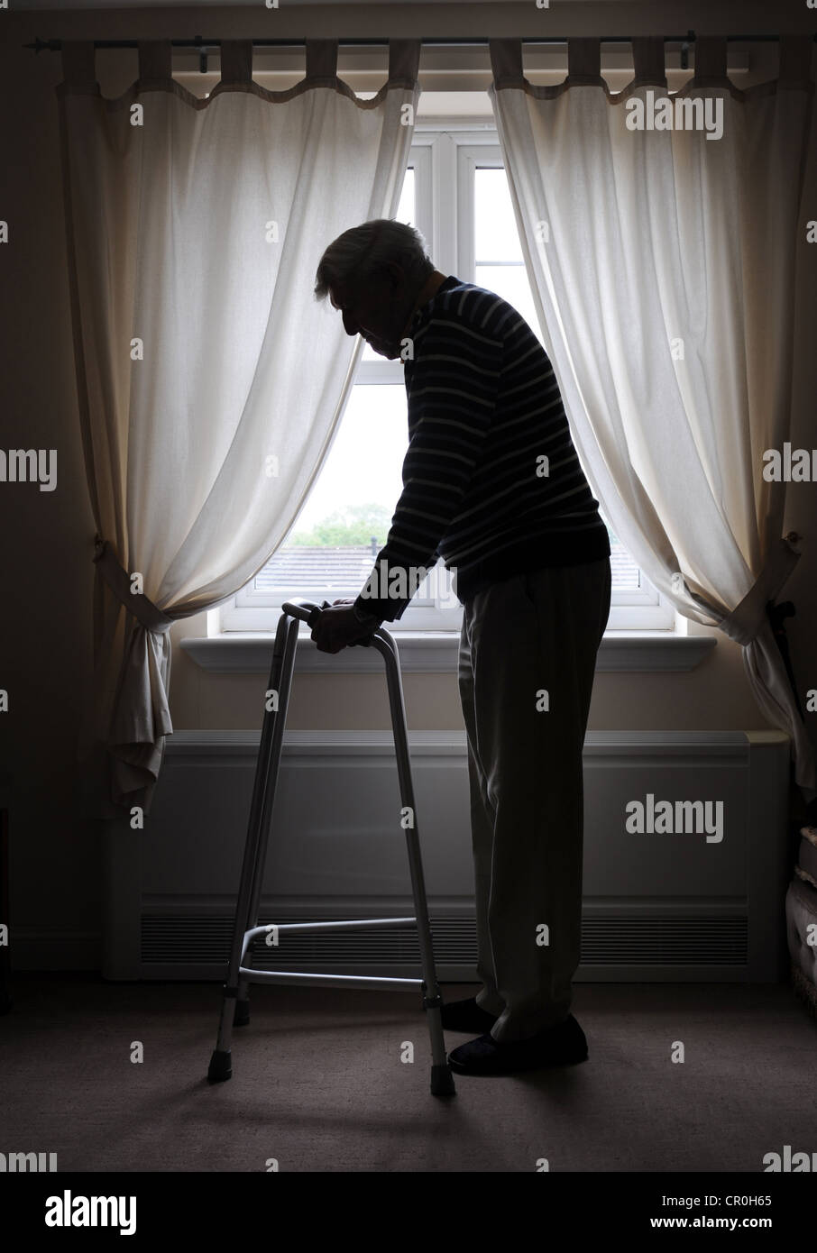OLD MAN PENSIONER WITH ZIMMER WALKING FRAME IN HOUSE RE OAP RETIREMENT OLD AGE PENSIONERS LONELY ALONE FRAIL CAREHOME CARERS UK Stock Photo