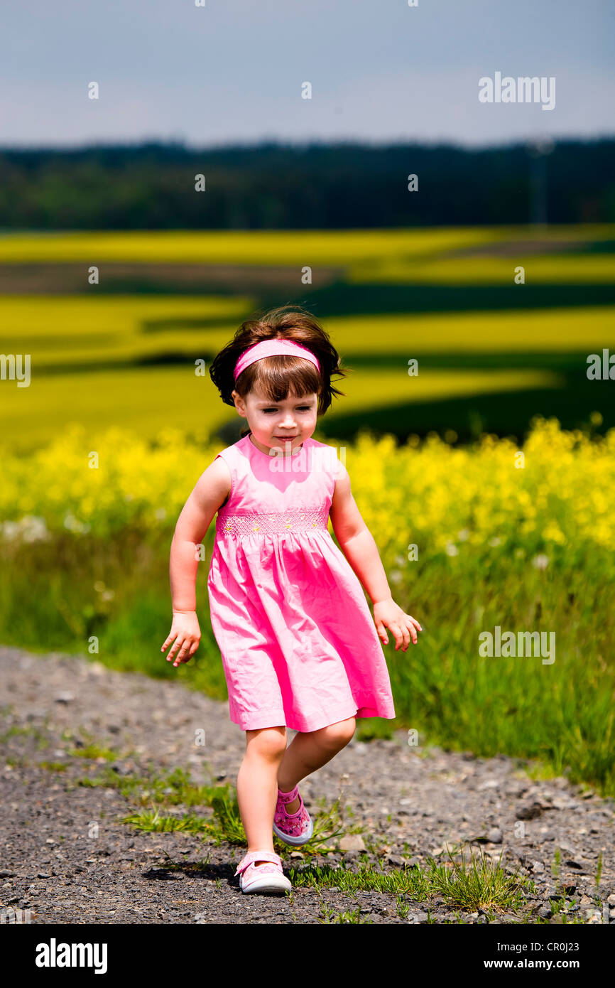 Little girl walking on field path Stock Photo - Alamy