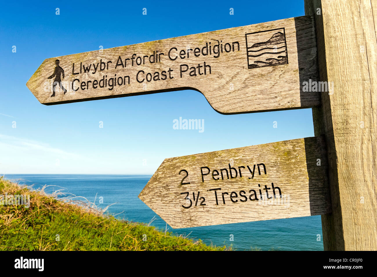 Ceredigion coastal path wooden signpost with sea and sky in background Stock Photo