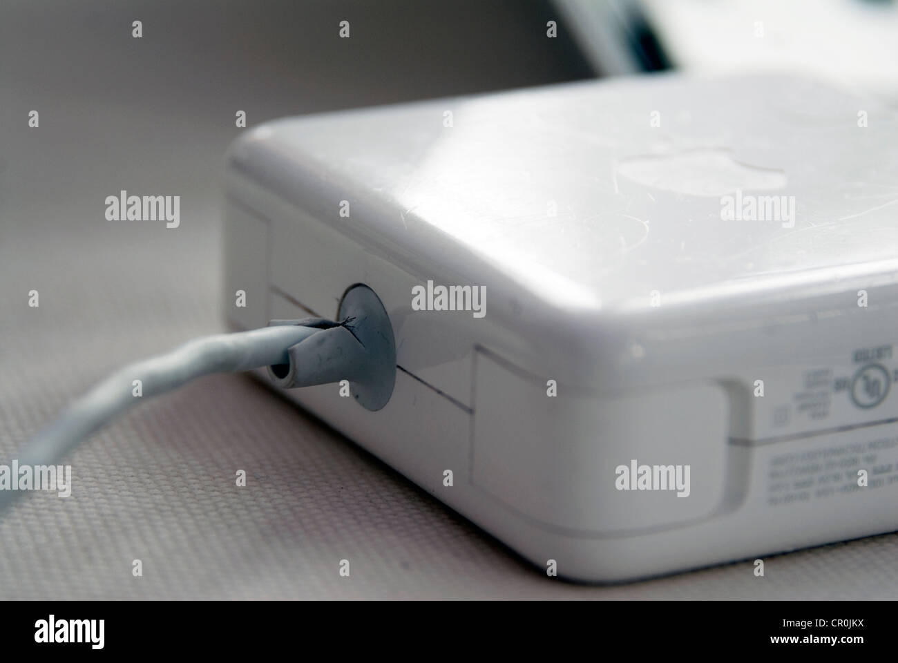Apple MacBook Pro faulty T MagSafe power adapter MacBook fray frayed Mag Safe adapters cord cords separation between white insul Stock Photo