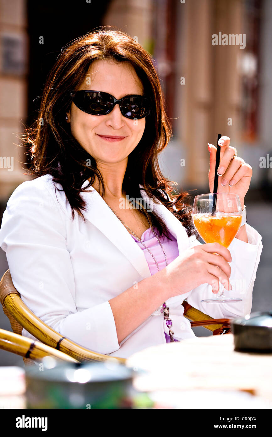 Young woman sitting in a street café Stock Photo - Alamy
