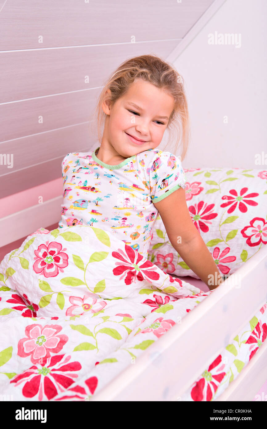 Little girl waking up in bed Stock Photo