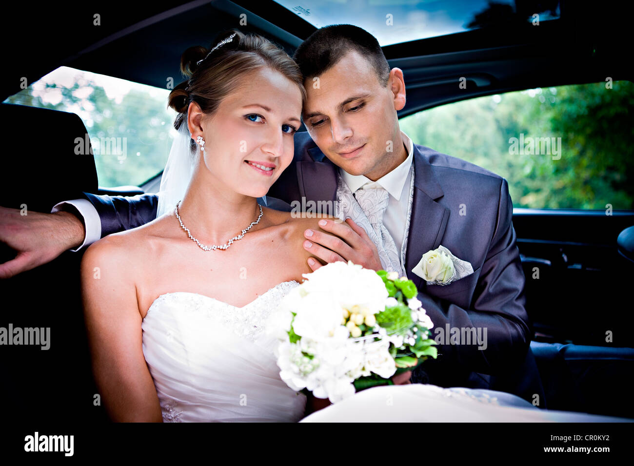 Young bridal couple in a car Stock Photo