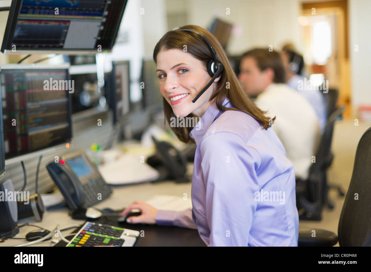 USA, New York, New York City, Portrait of female trader at trading desk