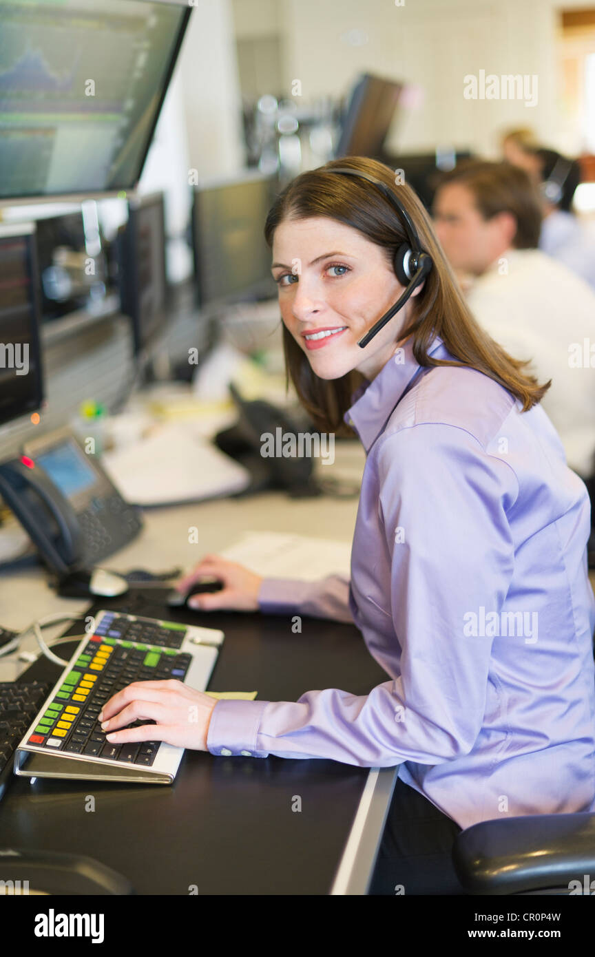USA, New York, New York City, Portrait of female trader at trading desk