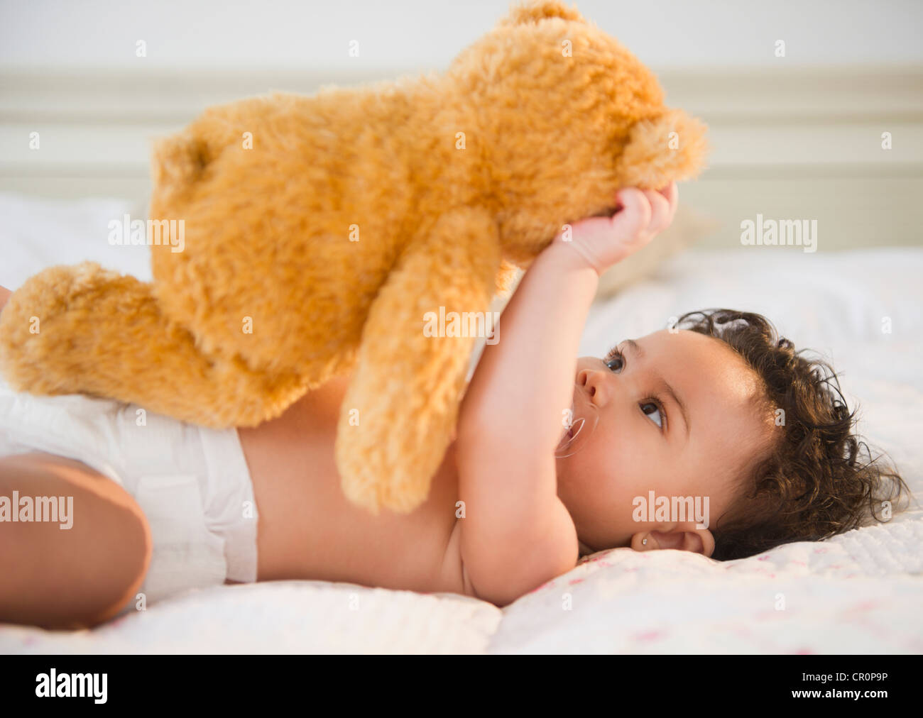 Mixed race baby holding teddy bear Stock Photo - Alamy