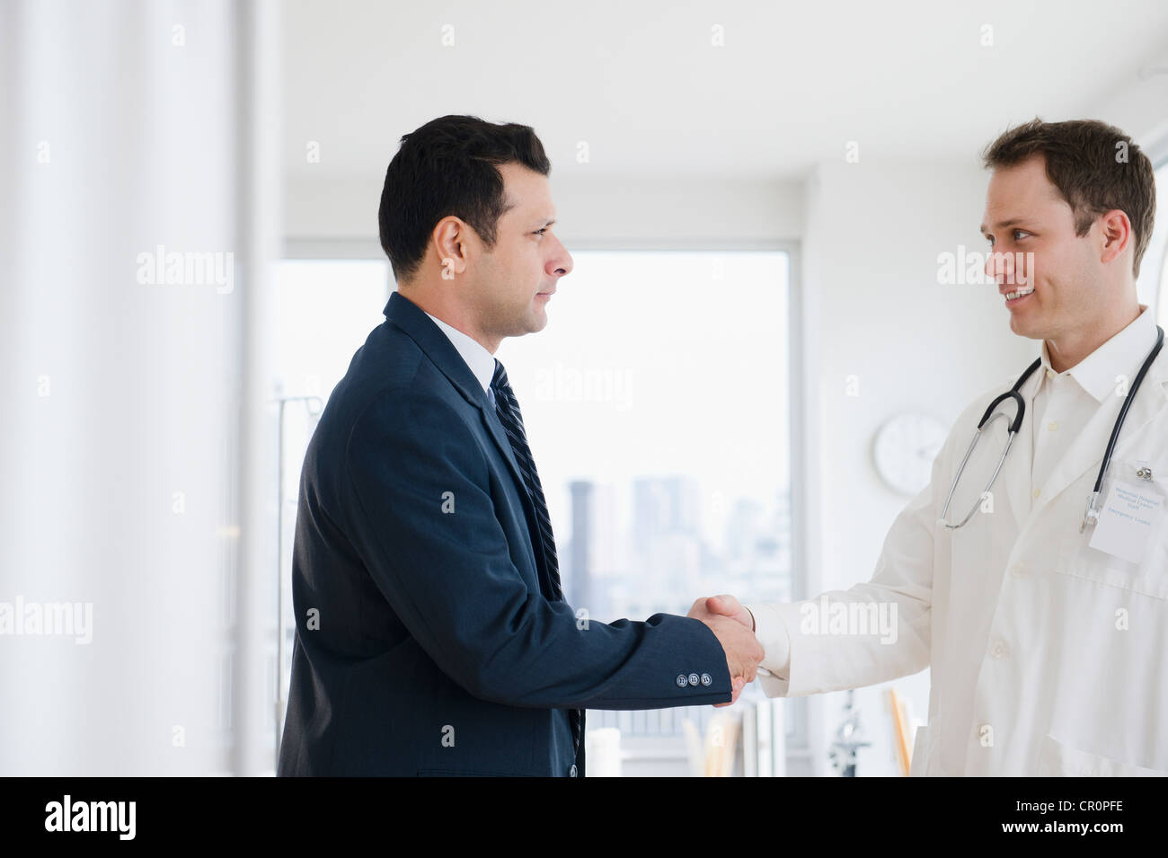 Businessman shaking hands with doctor Stock Photo Alamy