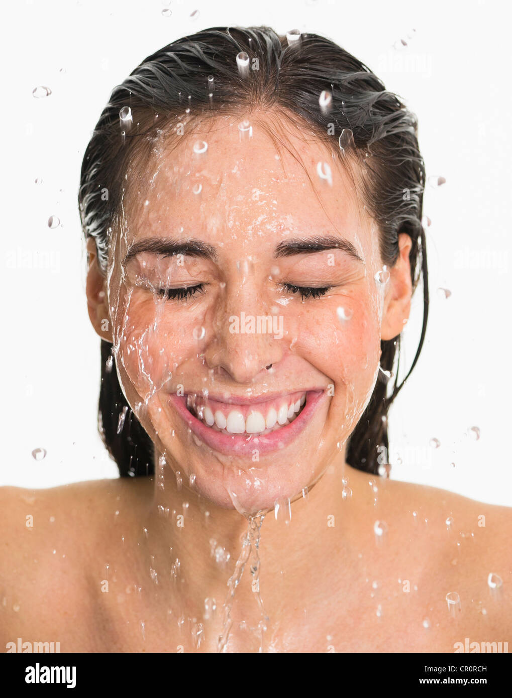 Studio shot of woman with splash of water on face Stock Photo
