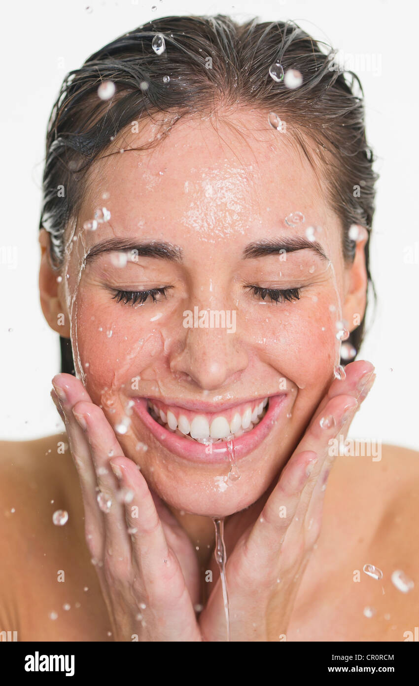 Studio shot of woman with splash of water on face Stock Photo