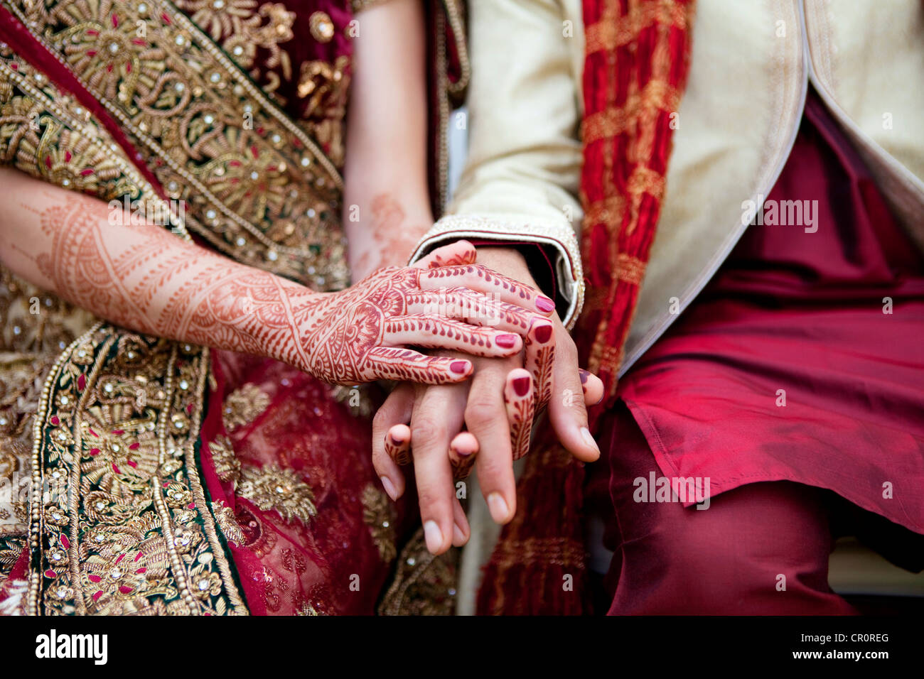 Bride and groom in traditional Indian wedding clothing with henna tattoos Stock Photo