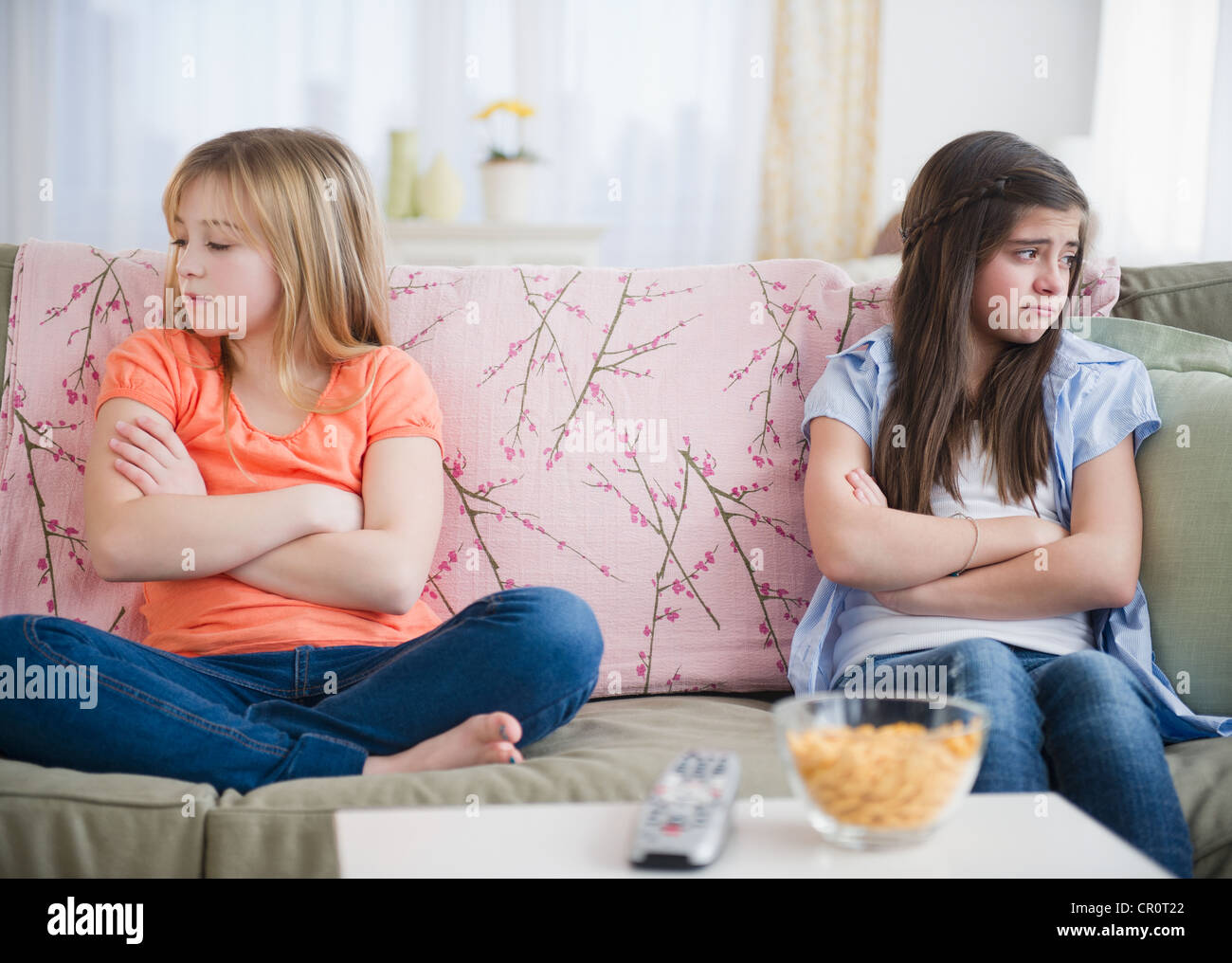 USA, New Jersey, Jersey City, Two girls sitting on sofa and showing disgust Stock Photo