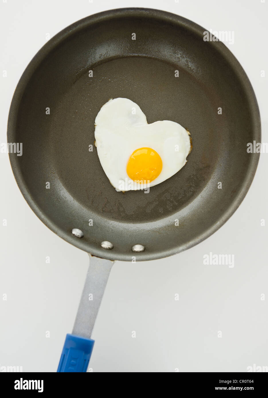 Close up of fried egg in heart shape on frying pan, studio shot Stock ...