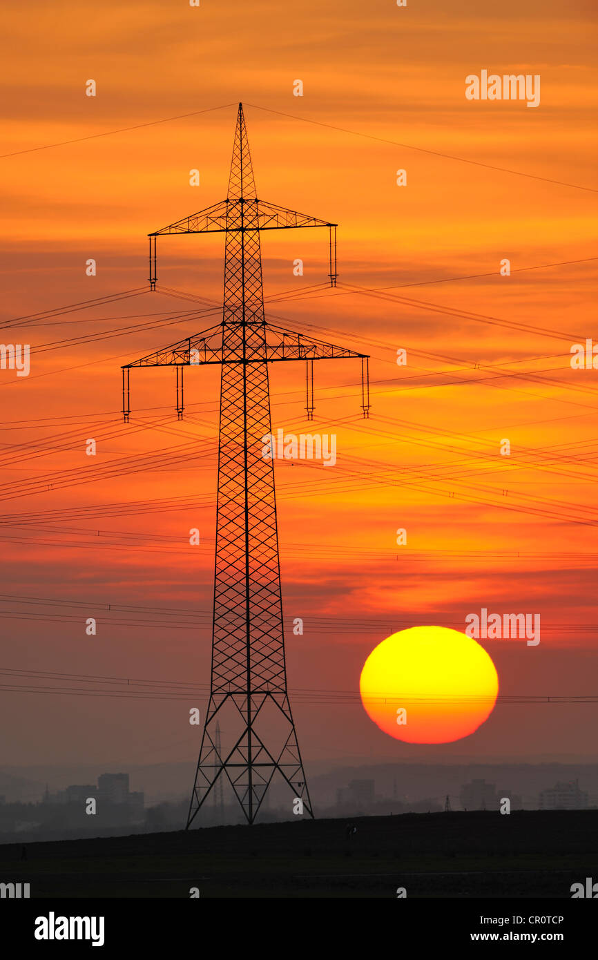 Electric power transmission lines, electricity pylon, with the setting sun, Beinstein near Stuttgart, Baden-Wuerttemberg Stock Photo