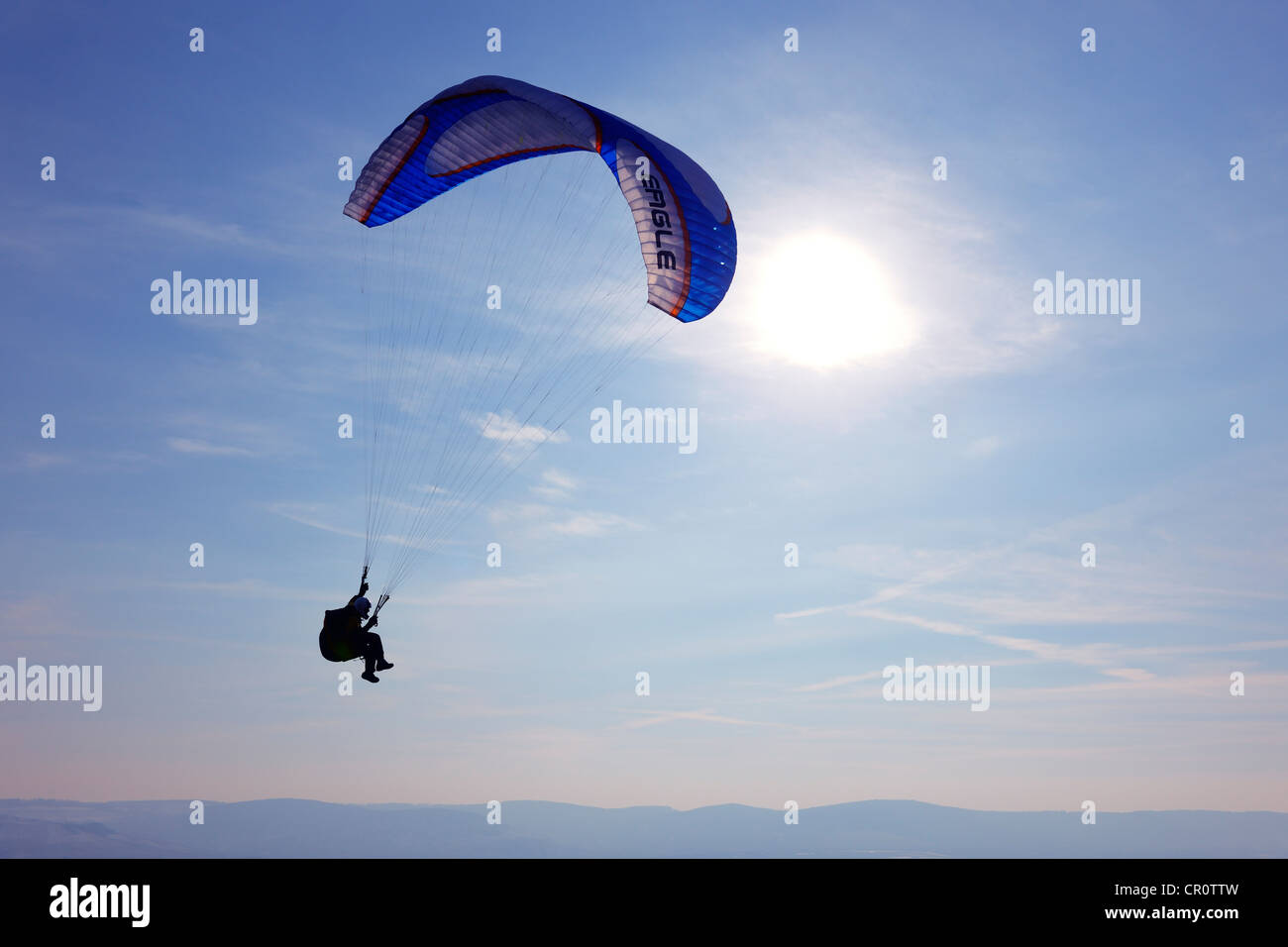 Paraglider in front of the sun Stock Photo