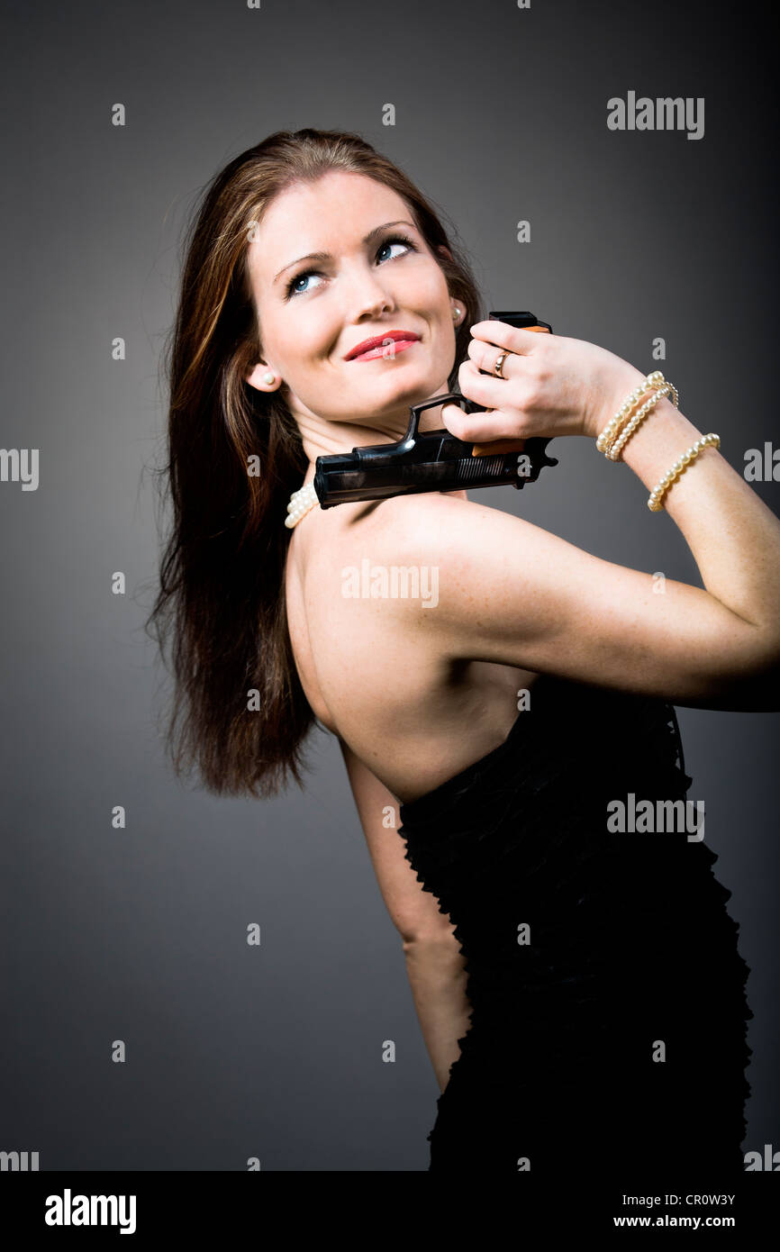 Young woman holding a gun Stock Photo