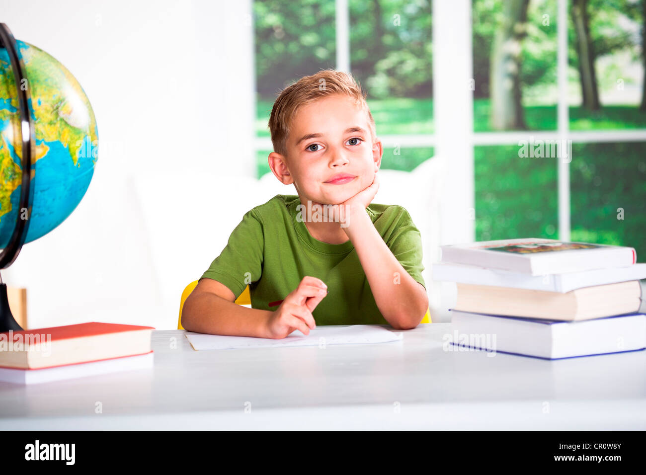 Boy with books at a table Stock Photo - Alamy