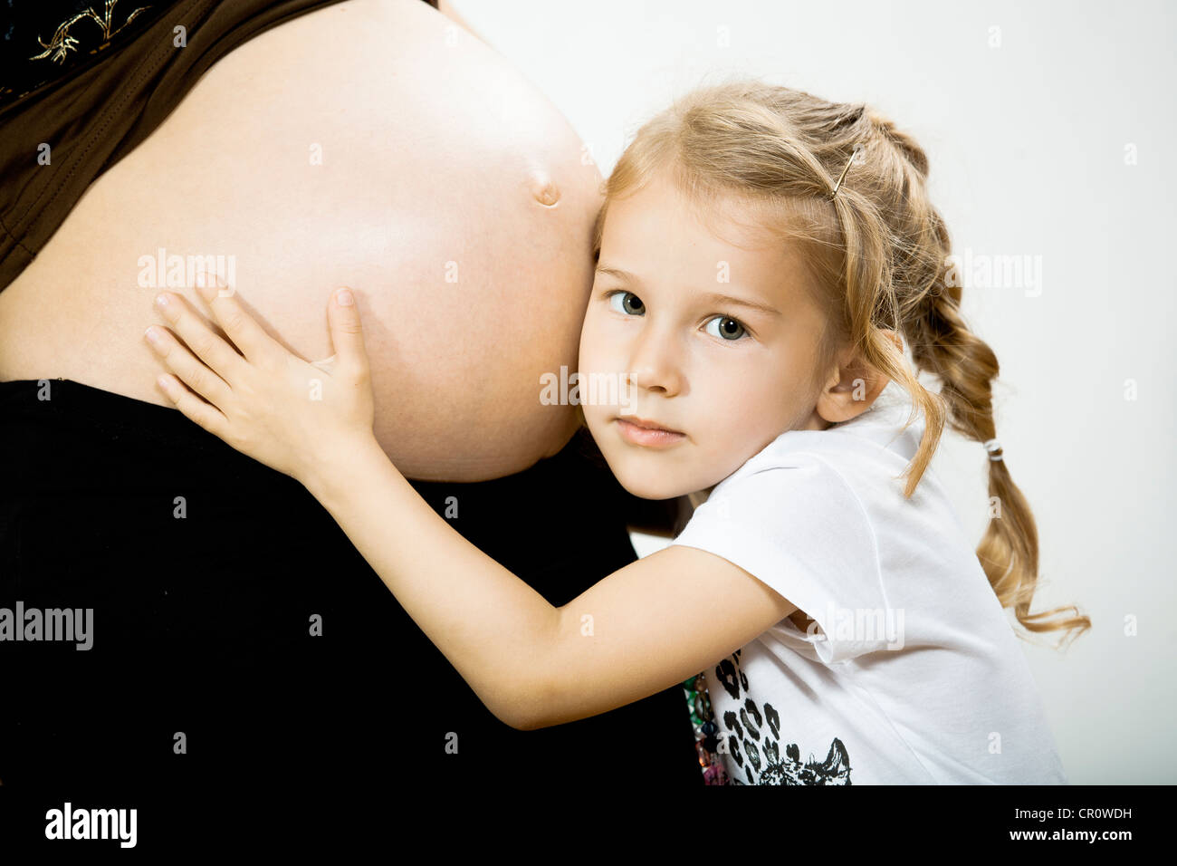 Girl and belly of pregnant mother Stock Photo
