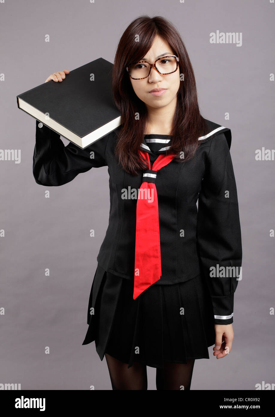 School girl lifts a heavy book Stock Photo - Alamy