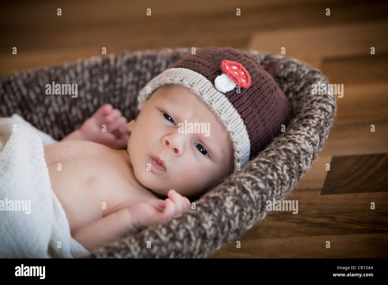 Newborn baby, 3 weeks, wearing a hat 