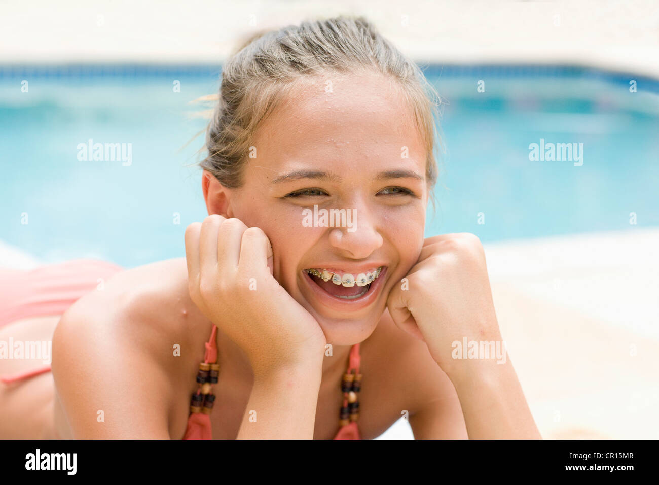 Teenage girl in braces relaxing by pool Stock Photo Alamy