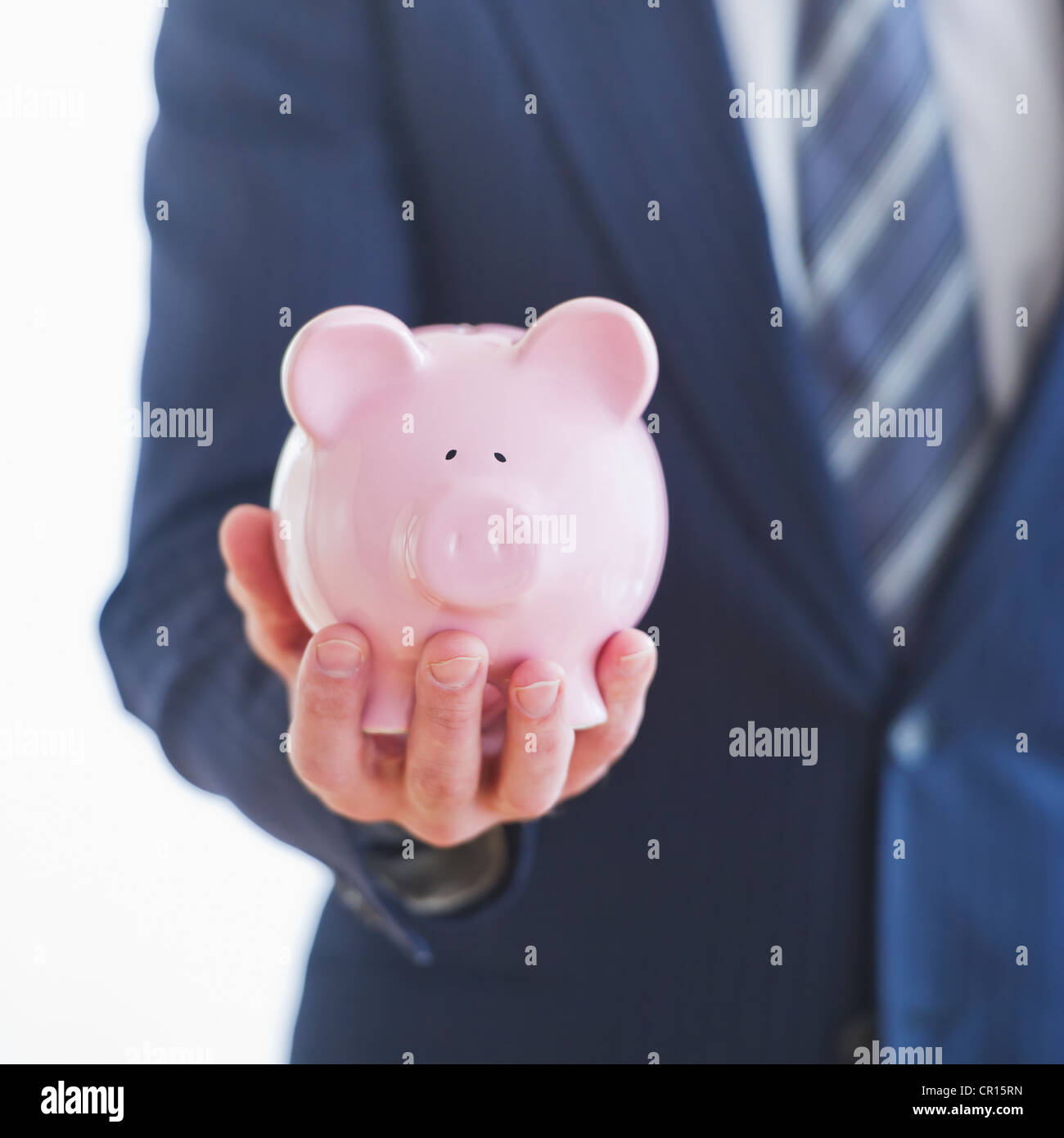 Man wearing suit holding piggybank Stock Photo - Alamy