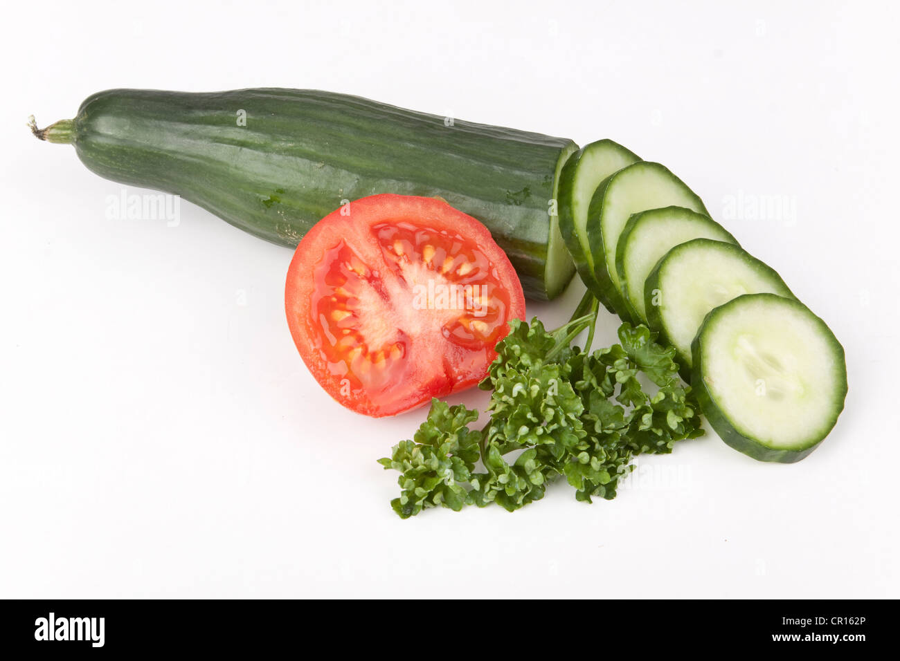 Cucumber with cucumber slices, tomato and parsley Stock Photo - Alamy