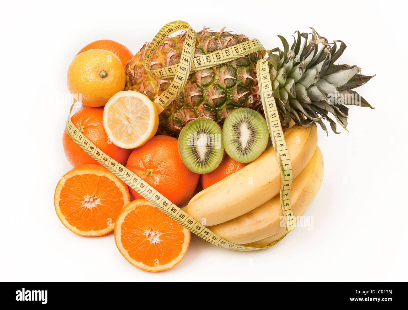 Fruits with a measuring tape, a pineapple, oranges, a lemon, a kiwi fruit and bananas Stock Photo