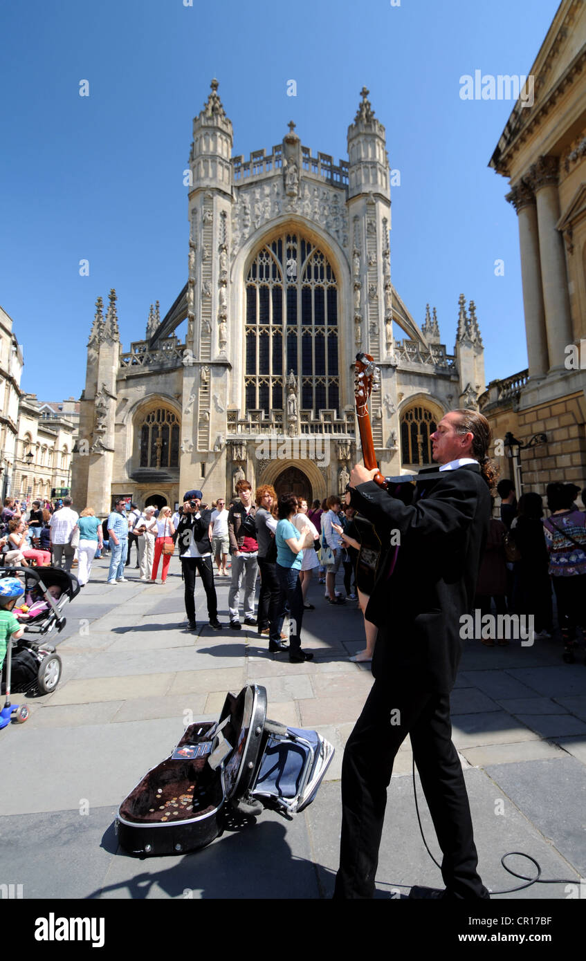 Bath Abbey in Bath, Somerset, Britain, UK, busker plays guitar in front of Bath Abbey Stock Photo