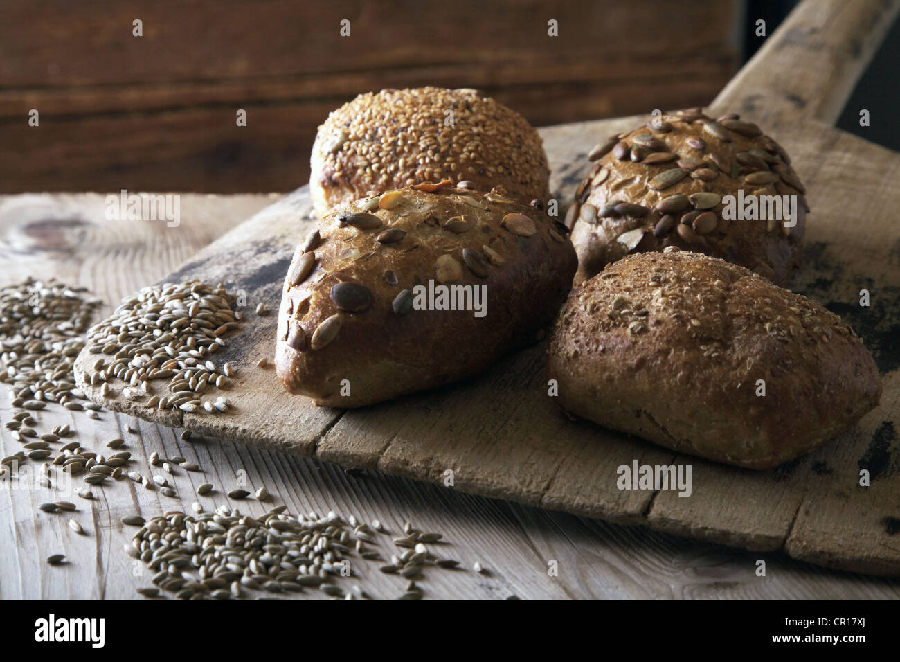 Rye bread rolls on an old bread slide with rye grains Stock Photo