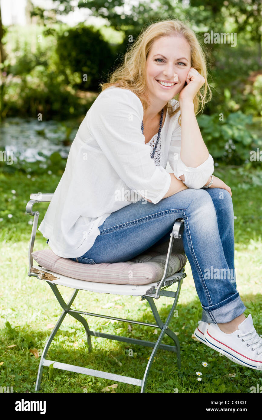 Smiling woman sitting outdoors Stock Photo - Alamy