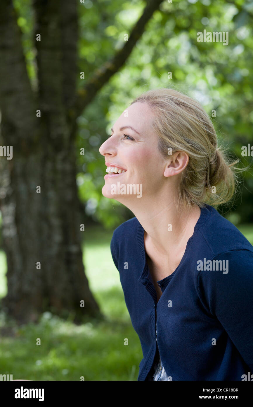 Smiling woman sitting outdoors Stock Photo