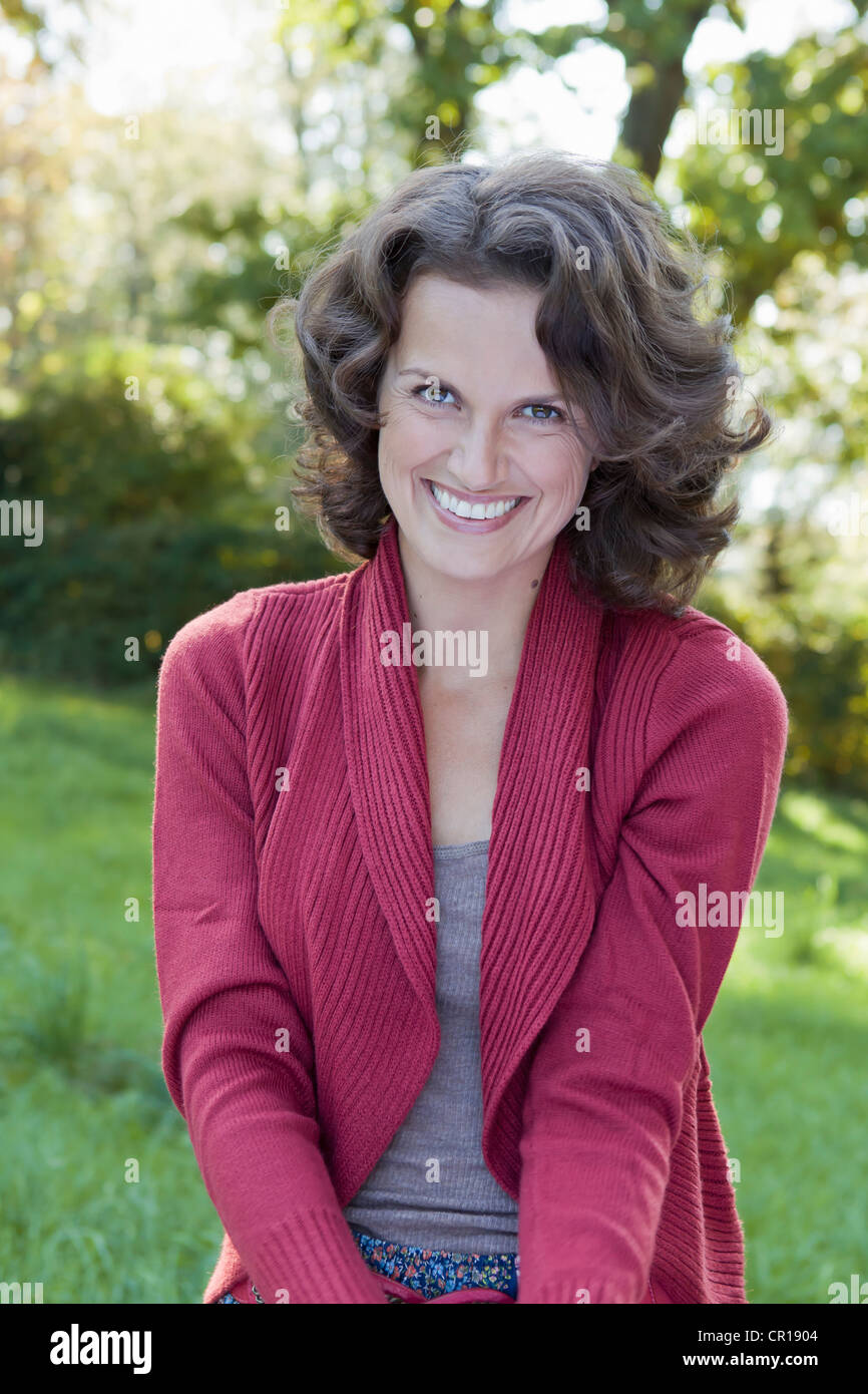 Smiling woman sitting outdoors Stock Photo - Alamy