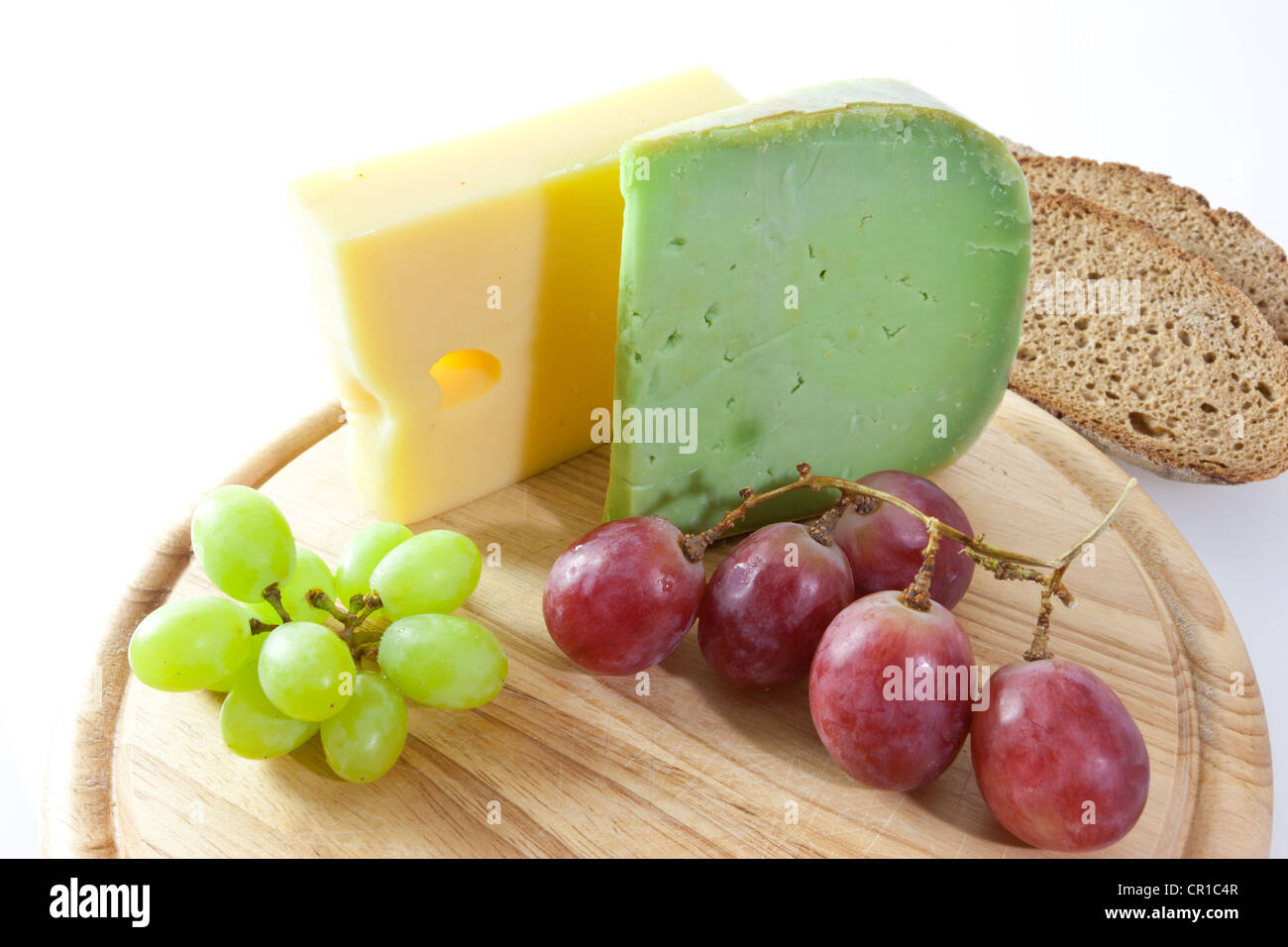 Spicy Japanese wasabi cheese and Emmental cheese on a board with grapes