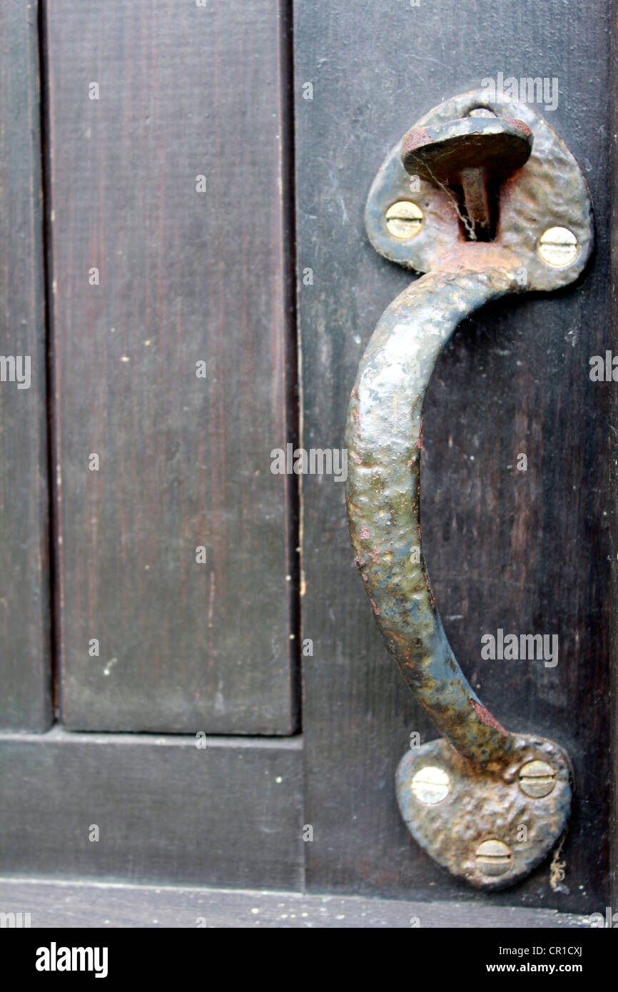 Old wrought iron door knob on a wooden door Stock Photo